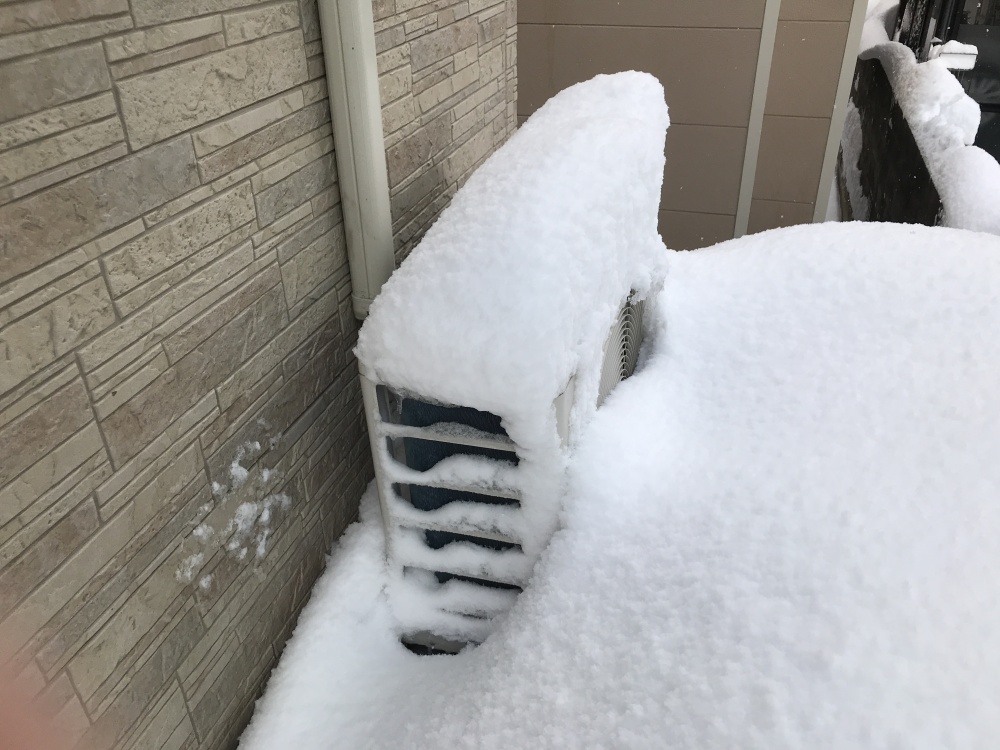 雪に埋まるエアコンの室外機（金沢市）